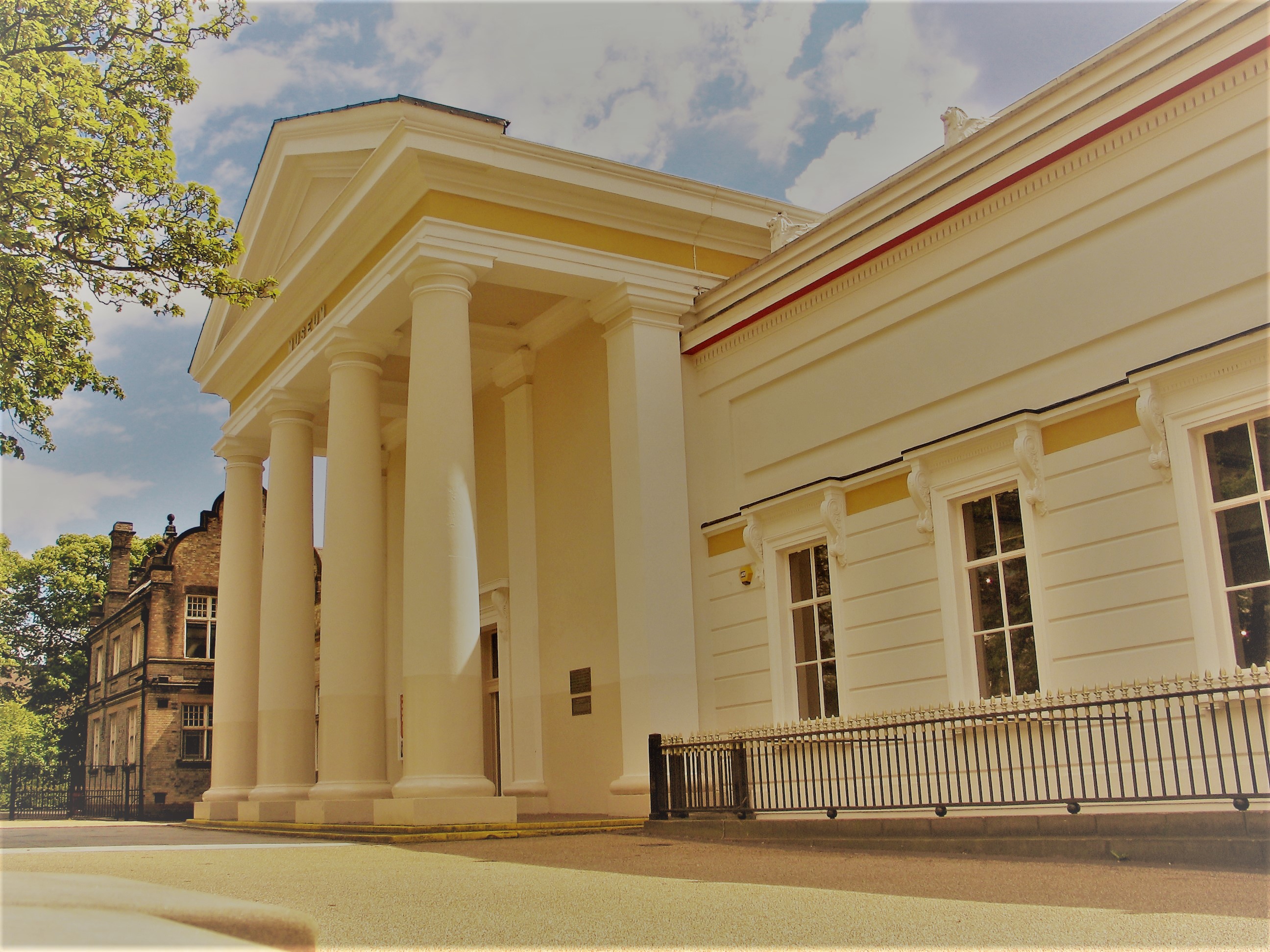 Front of large white museum with columns